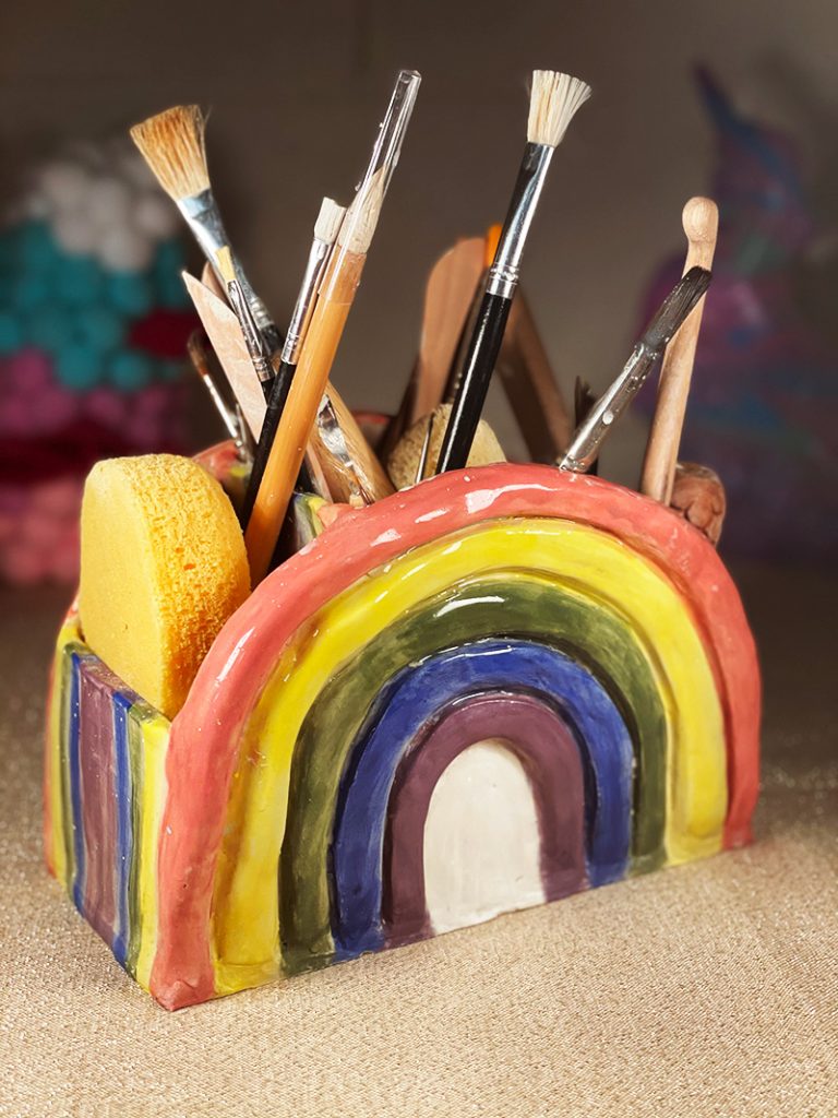 Rainbow holder containing paintbrushes and pottery tools